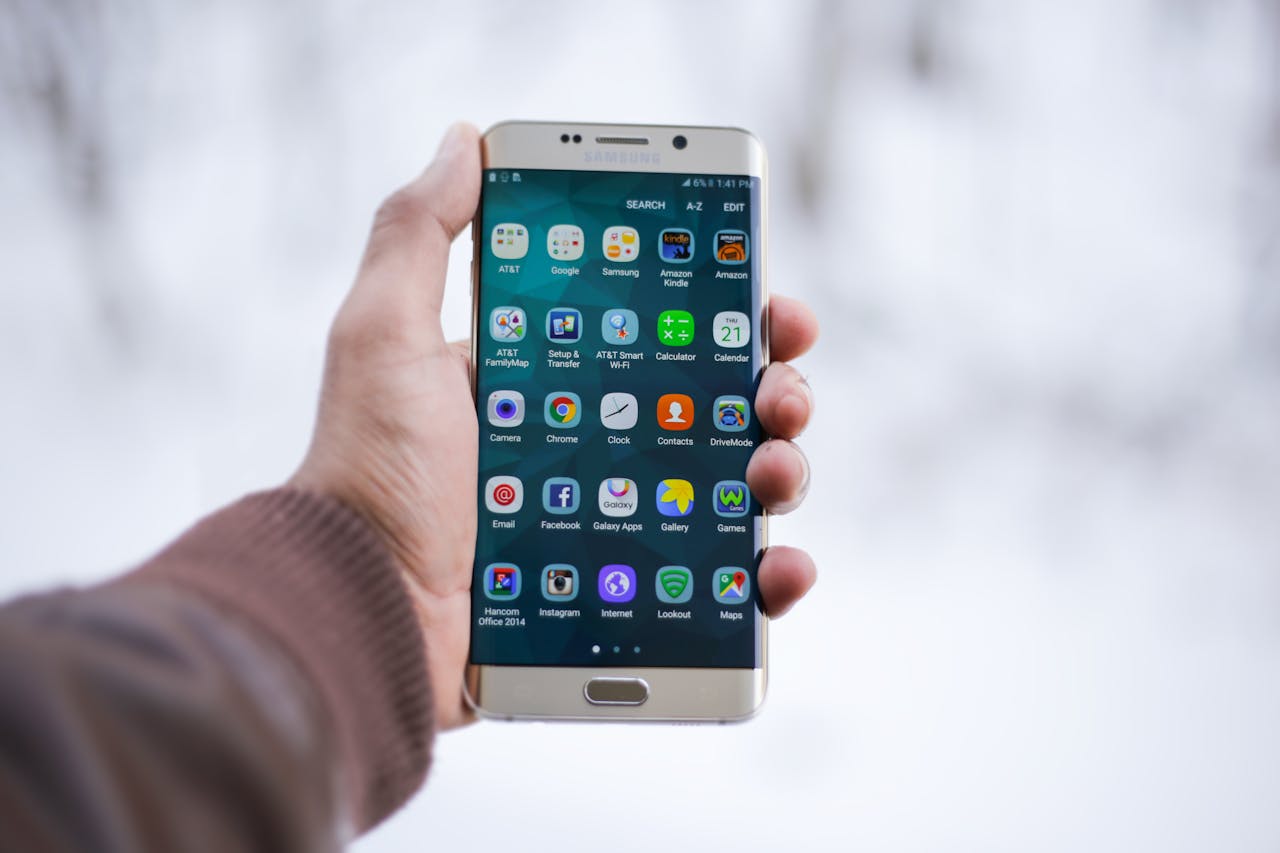 The Art of Drawing Readers In: Your attractive post title goes here Close-up of a hand holding a Samsung smartphone displaying various app icons, emphasizing technology and connectivity.